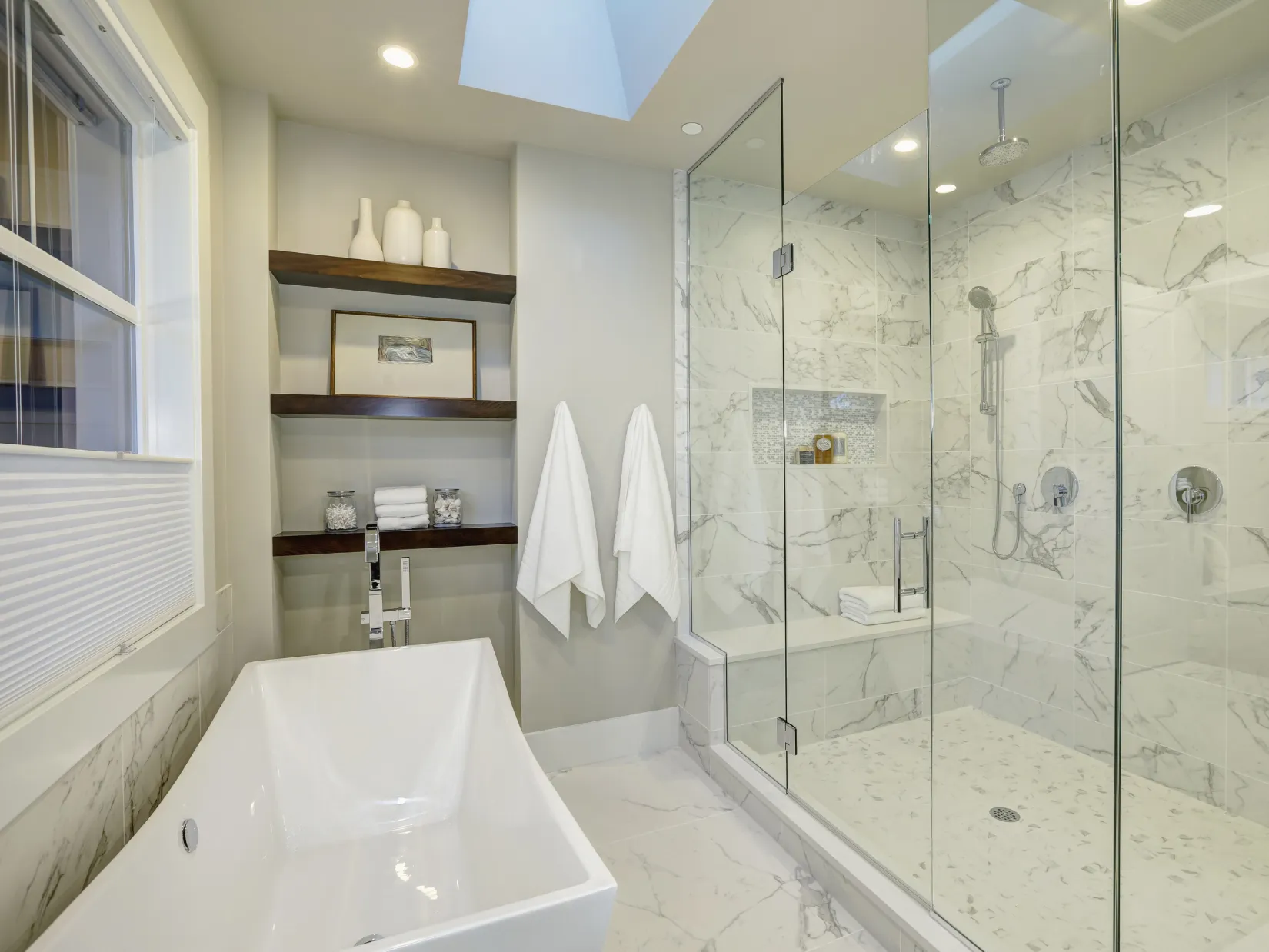 Modern bathroom renovation in Dallas featuring a luxury walk-in shower with glass enclosure, marble-look tile walls, and a freestanding soaking tub.
